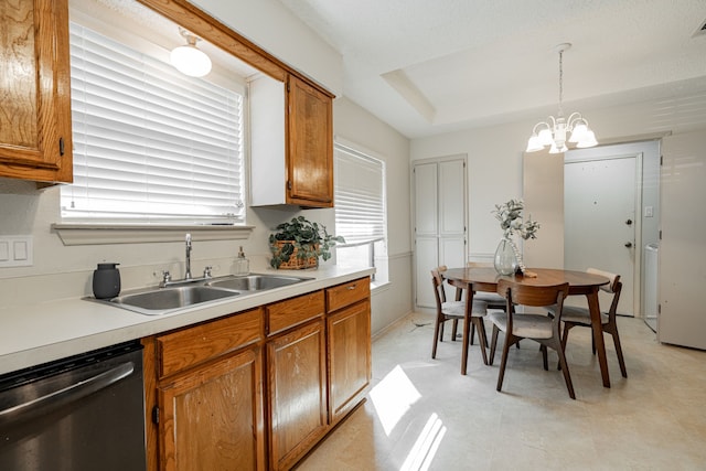 kitchen featuring dishwashing machine, brown cabinets, hanging light fixtures, light countertops, and a sink