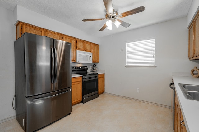 kitchen featuring stainless steel fridge, a textured ceiling, ceiling fan, sink, and electric range