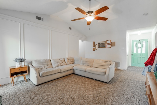 living area featuring light carpet, visible vents, vaulted ceiling, and a decorative wall