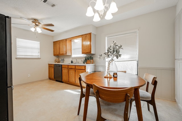 dining space featuring a textured ceiling, ceiling fan with notable chandelier, and sink