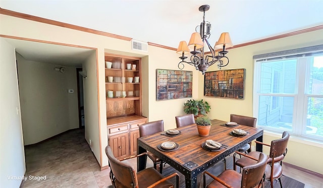 dining space with crown molding, a chandelier, a healthy amount of sunlight, and built in features