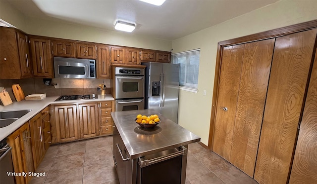 kitchen featuring light tile patterned floors, backsplash, and stainless steel appliances