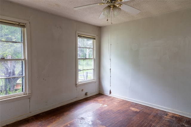 unfurnished room featuring a textured ceiling, dark wood-type flooring, and ceiling fan