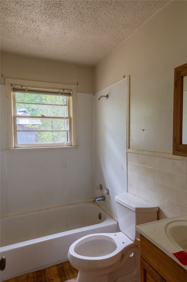 full bathroom with vanity, toilet, bathtub / shower combination, and tile walls