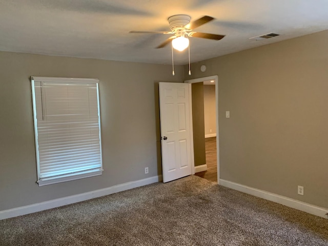 empty room featuring carpet flooring and ceiling fan