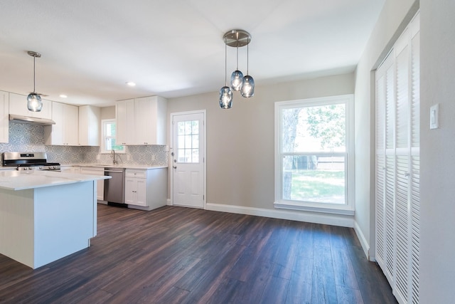 kitchen featuring stainless steel appliances, pendant lighting, plenty of natural light, white cabinetry, and dark hardwood / wood-style flooring