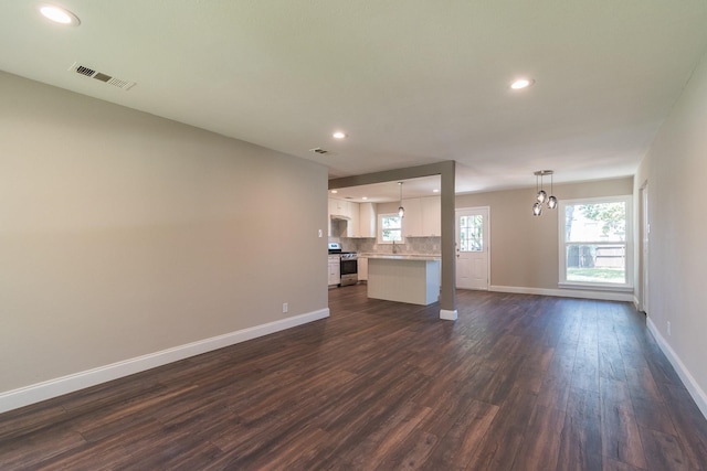 unfurnished living room featuring sink and dark hardwood / wood-style floors