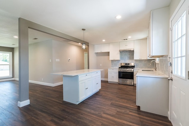 kitchen featuring white cabinetry, stainless steel stove, hanging light fixtures, and dark hardwood / wood-style floors