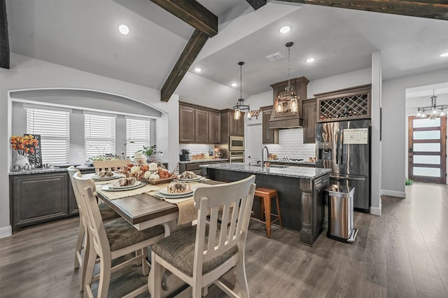 dining space featuring a notable chandelier, vaulted ceiling with beams, and dark hardwood / wood-style floors