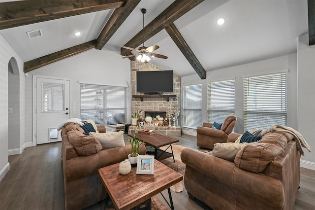 living room with a healthy amount of sunlight, beamed ceiling, and dark hardwood / wood-style flooring