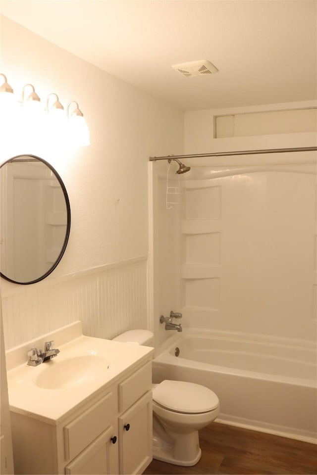 full bathroom featuring vanity, wood-type flooring, shower / bathtub combination, and toilet