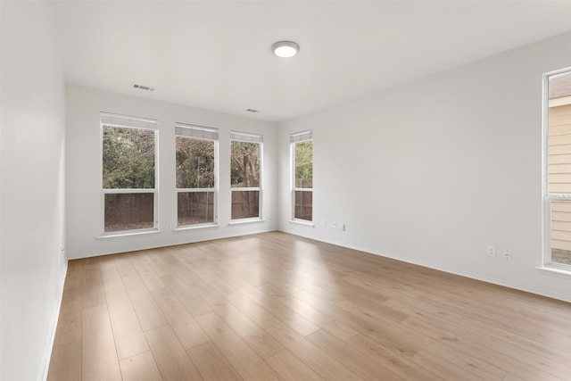 unfurnished room featuring light hardwood / wood-style floors and a healthy amount of sunlight