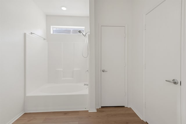 bathroom with shower / tub combination and hardwood / wood-style floors