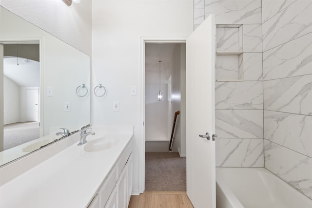 bathroom featuring vanity, hardwood / wood-style flooring, and tiled shower / bath