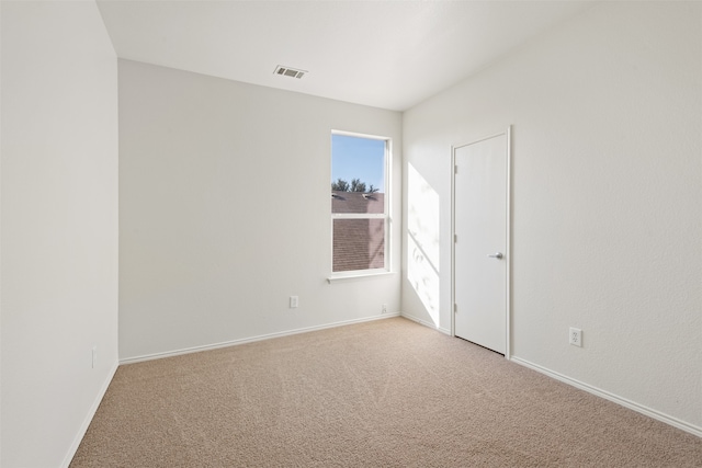 spare room featuring light carpet