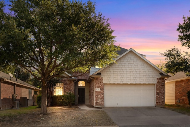 view of front of home featuring central AC unit and a garage