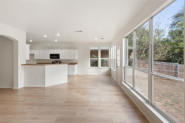 interior space with white cabinetry, plenty of natural light, and light wood-type flooring