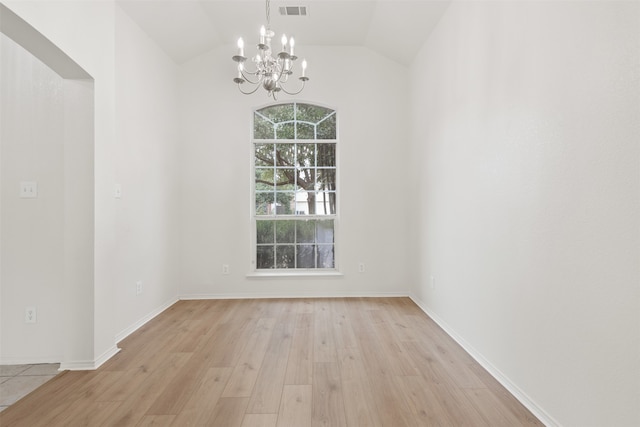 unfurnished dining area with light hardwood / wood-style floors, lofted ceiling, and an inviting chandelier