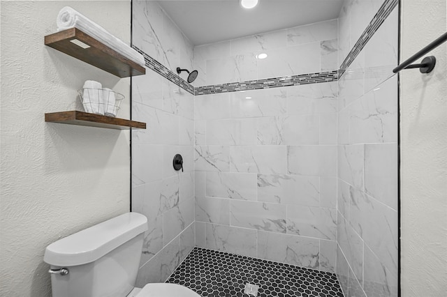 bathroom with toilet and tiled shower