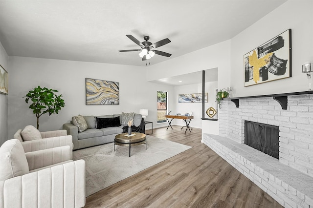 living room featuring light hardwood / wood-style flooring, a fireplace, and ceiling fan