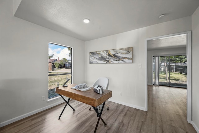 office space with wood-type flooring, a textured ceiling, and plenty of natural light