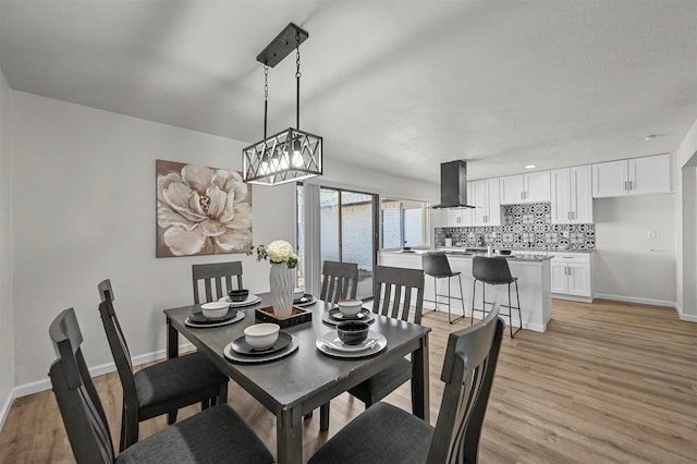 dining space with a notable chandelier and light wood-type flooring