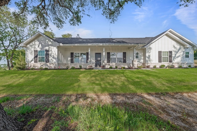 ranch-style home featuring board and batten siding, a shingled roof, and a front lawn