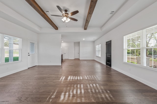 unfurnished living room with ceiling fan, wood finished floors, beam ceiling, and visible vents