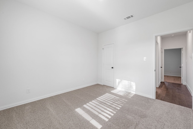 carpeted empty room with visible vents and baseboards