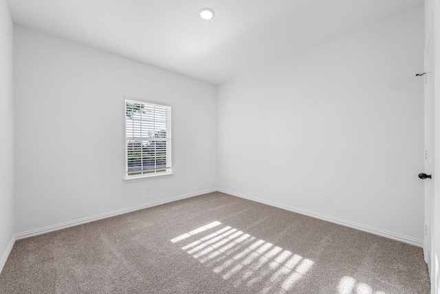carpeted spare room with baseboards