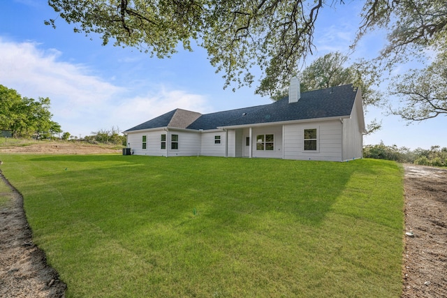 back of property with a yard and a chimney