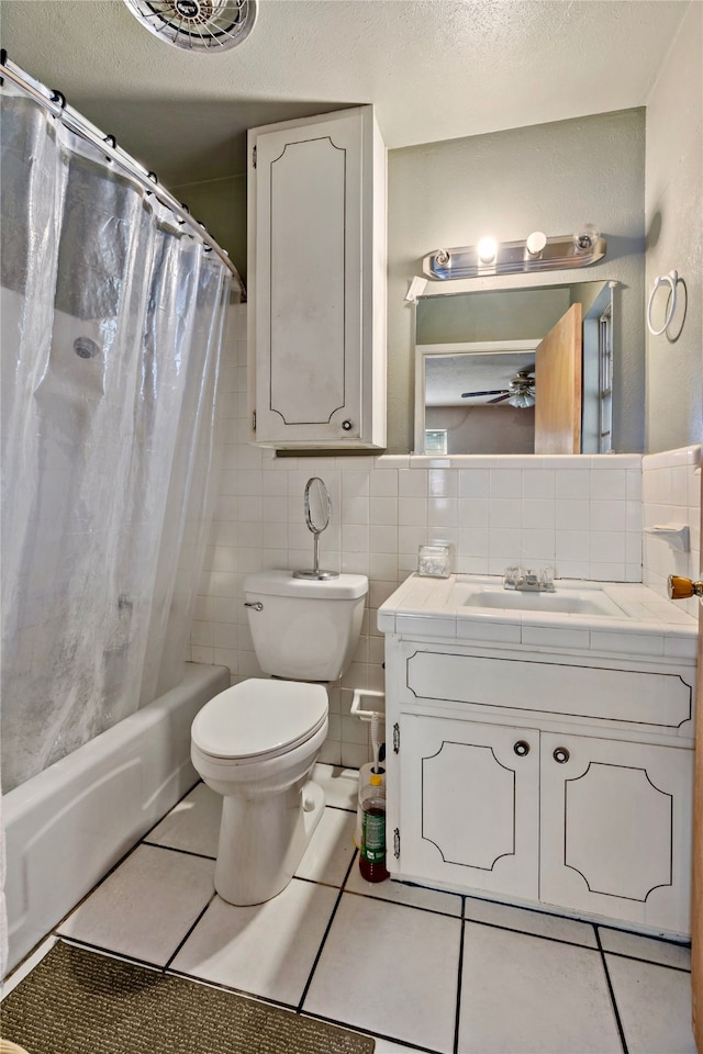 full bathroom with tile patterned floors, toilet, vanity, tile walls, and shower / bathtub combination with curtain