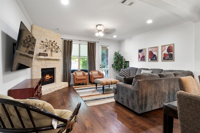 living room with ceiling fan, a stone fireplace, dark hardwood / wood-style flooring, and ornamental molding