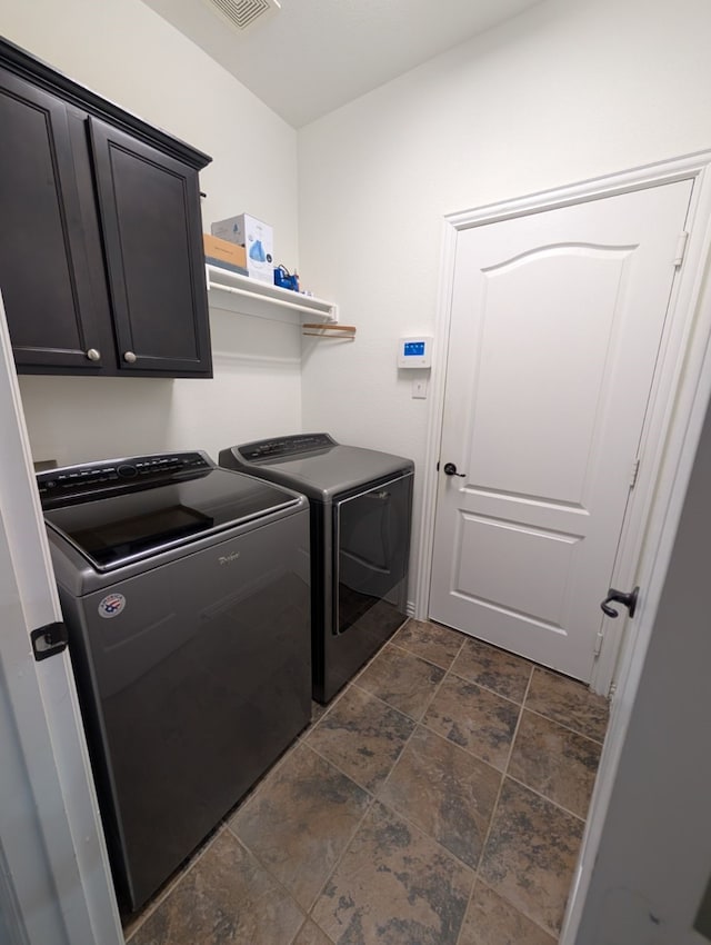 laundry room with washer and clothes dryer and cabinets