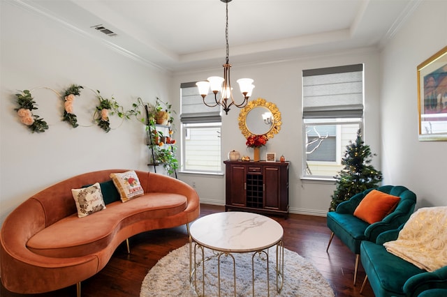 living room with a notable chandelier, crown molding, dark wood-type flooring, and a tray ceiling