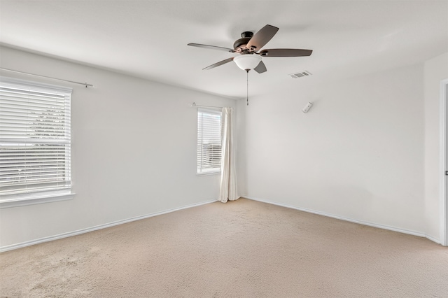 spare room featuring light colored carpet and ceiling fan