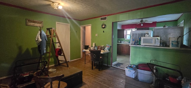 interior space featuring crown molding, hardwood / wood-style floors, a textured ceiling, and ceiling fan