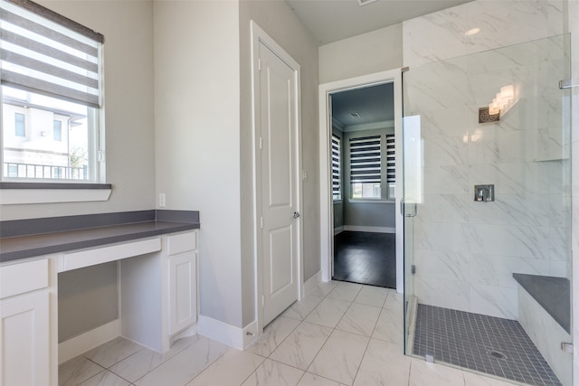 bathroom featuring a shower with door and vanity