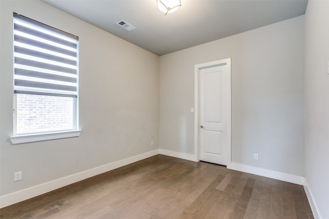 spare room with a textured ceiling and hardwood / wood-style flooring