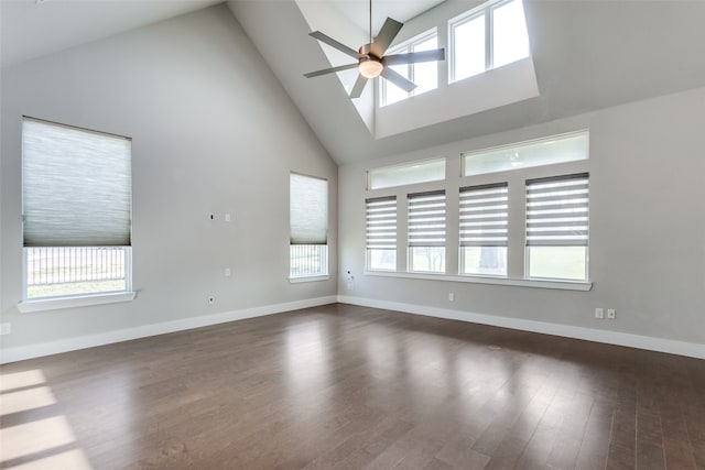 unfurnished room with ceiling fan, high vaulted ceiling, a skylight, and dark hardwood / wood-style flooring