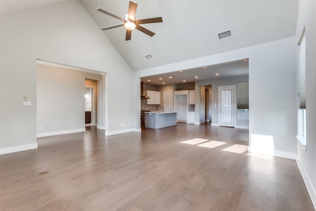 unfurnished living room with high vaulted ceiling, wood-type flooring, and ceiling fan