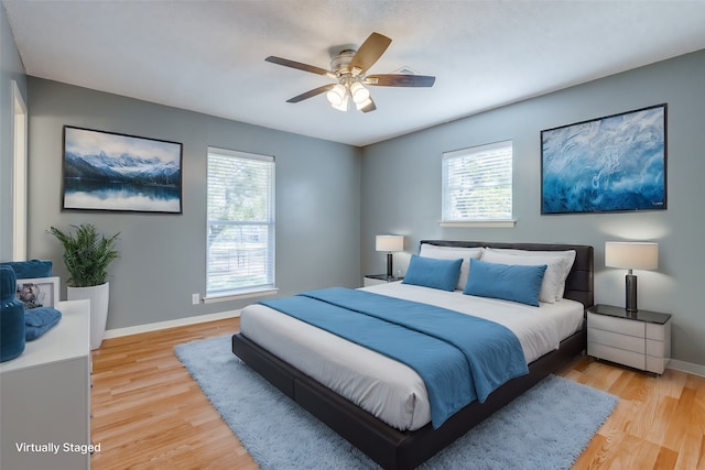 bedroom featuring light hardwood / wood-style flooring, multiple windows, and ceiling fan