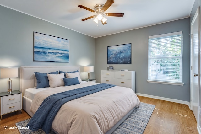 bedroom featuring ornamental molding, light wood-type flooring, and ceiling fan