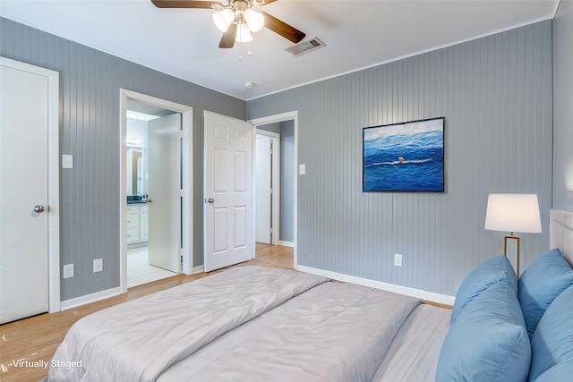 bedroom featuring ensuite bath, light wood-type flooring, and ceiling fan