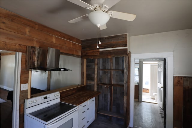 kitchen with wood walls, white cabinetry, wall chimney exhaust hood, and electric stove