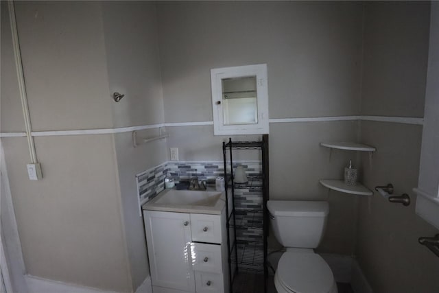 bathroom with vanity, backsplash, and toilet