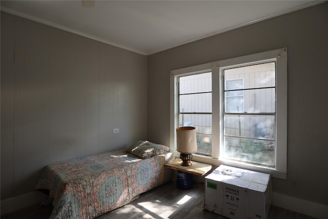 bedroom with crown molding and dark hardwood / wood-style flooring