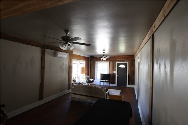 interior space with ceiling fan, wood-type flooring, wooden walls, and a wall unit AC