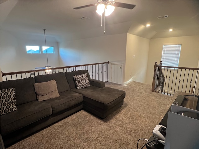 carpeted living room with ceiling fan and vaulted ceiling