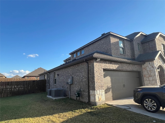 view of side of home featuring central AC, a garage, and a lawn